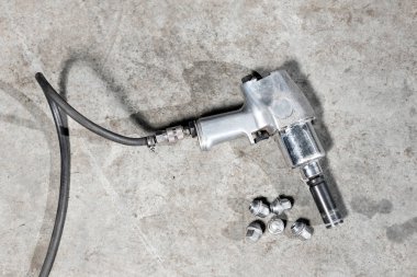 bir Tamirhane, askıya alınmış bir araba lastiği sıkılaştırmak için hava tabancası cıvata