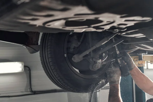 Hinterachse des Autos. der Werkstattmechaniker hob das Auto auf den Aufzug — Stockfoto