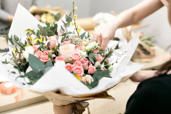 Workshop florist, making bouquets and flower arrangements. Woman collecting a bouquet of flowers. Soft focus
