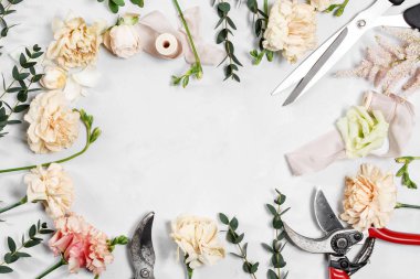 Beyaz ahşap zemin üzerinde çalışma araçları çiçekçi masaüstüyle