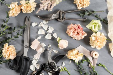 Çiçekçi masaüstü gri ahşap arka plan üzerinde çalışma araçları ile. kopya alanı
