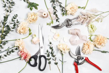 Beyaz ahşap zemin üzerinde çalışma araçları çiçekçi masaüstüyle