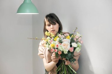 Atölye çiçekçi, buketler ve çiçek düzenlemeleri yapma. Bir buket çiçek toplama kadın. Yumuşak odak