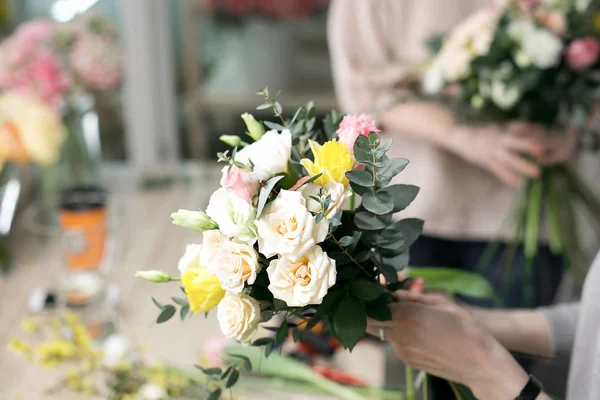 Florista de taller, haciendo ramos y arreglos florales. Mujer recogiendo un ramo de flores. Enfoque suave — Foto de Stock