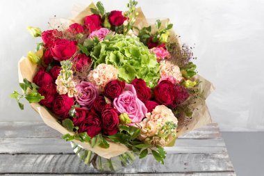 Gül ve diğer lüks ve şık buket çiçek ahşap arka plan, kopya alanı üzerinde renkleri.