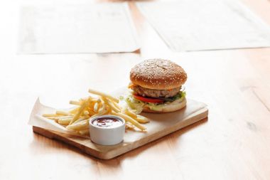 Büyük lezzetli hamburger ve patates kızartması ahşap tablo