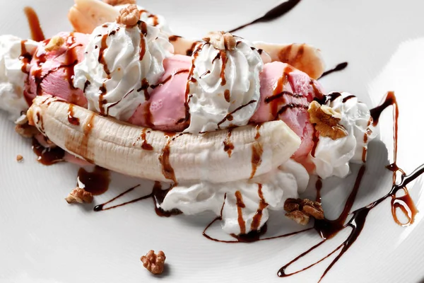 Banano tropical partido con llovizna de chocolate sobre tres cucharadas de chocolate, fresa y helado de vainilla sobre plátanos frescos — Foto de Stock