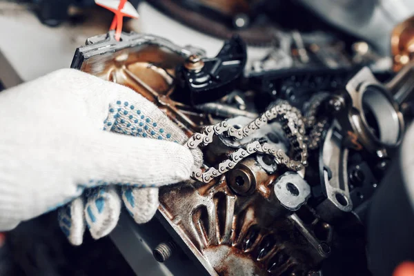 Mecánico reparador en los trabajos de reparación de mantenimiento de motores de automóviles. la cadena del motor — Foto de Stock