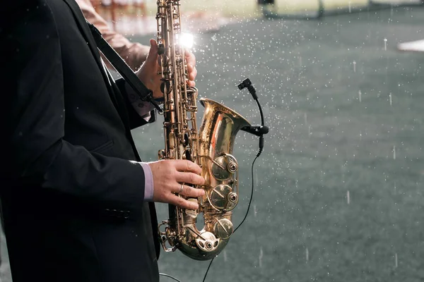 El hombre con saxofón está bajo la lluvia — Foto de Stock