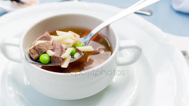 Una ciotola di deliziosa zuppa di manzo e orzo con carote, pomodoro, patate, sedano e piselli . — Video Stock