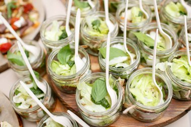 domates salatası, yeşil yapraklar ve mason beyaz peynir kavanozlar