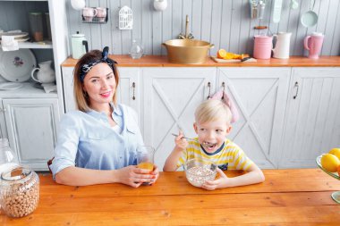 Anne ve oğul mutfakta bir kahvaltı yaparken gülüyorsun.