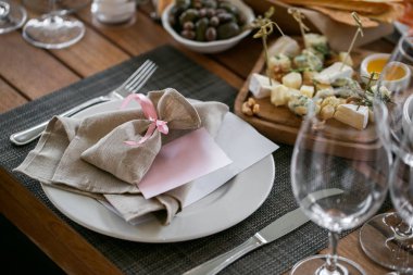 keten Tekstil. Süslü masa, bir tabak özenle düzenlenmiş peçete, çatal ve bıçak.