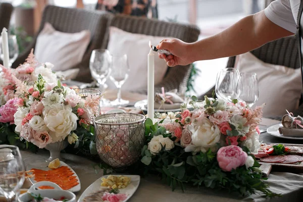 Düğün günü. Garson bir mum yanar. romantik bir akşam yemeği