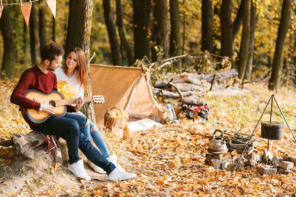 Sonbahar piknik. Mutlu çift gitar ile çadır yakınındaki. — Stok fotoğraf