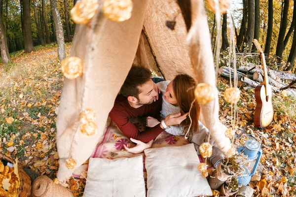 Erkek ve kadın yürüyüşçü sonbahar doğada kamp. Mutlu genç çift backpackers çadırda kamp.