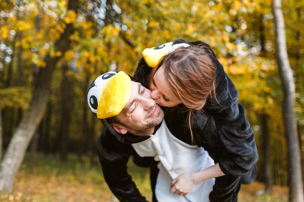 Casal em Combinar Pinguim Pajamas na floresta de outono — Fotografia de Stock