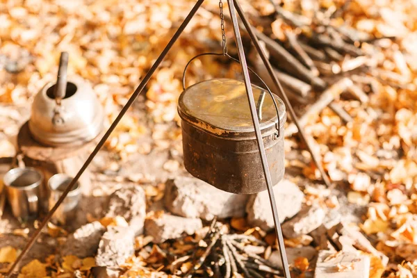 Matlagning över en lägereld i en gjutjärn gryta. Gjutjärn potten för soppa som hänger över eld lägerelden. — Stockfoto