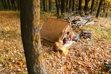 Erkek ve kadın yürüyüşçü sonbahar doğada kamp. Mutlu genç çift backpackers çadırda kamp.