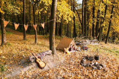 Erkek ve kadın yürüyüşçü sonbahar doğada kamp. Mutlu genç çift backpackers çadırda kamp.