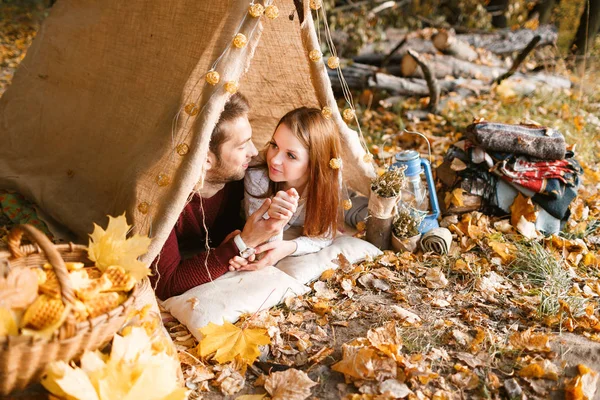 Erkek ve kadın yürüyüşçü sonbahar doğada kamp. Mutlu genç çift backpackers çadırda kamp.