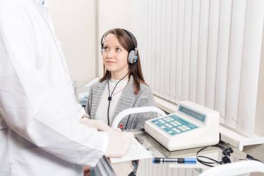 Doktor otolaryngologist hastaların muayene. kulaklıklar ile özel bir aparat işitme tanı.