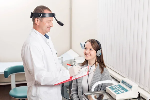 El doctor otorrinolaringólogo examinó a los pacientes. diagnóstico de audición de un aparato especial con auriculares . — Foto de Stock