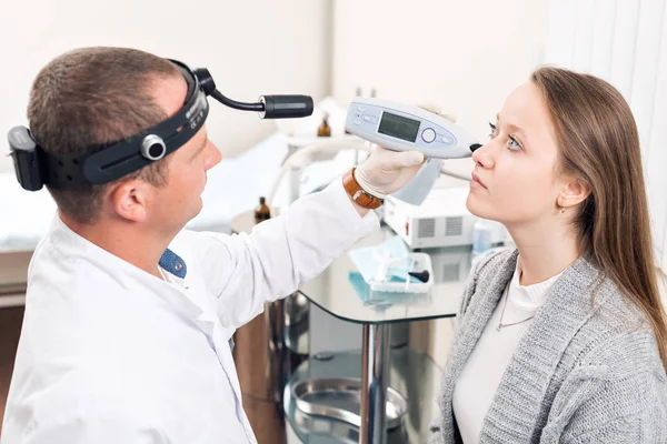 Otorrinolaringólogo. Trabajador médico muy atento mirando la nariz de su visitante —  Fotos de Stock