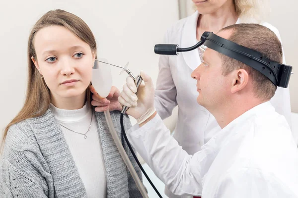 ORL lékař hledá do ucha pacientů s nástrojem. soukromá klinika. otorinolaryngologů — Stock fotografie