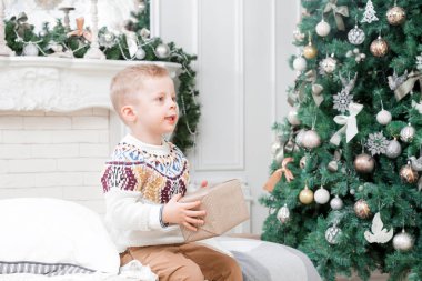 Noel sabahı mutlu litle çocuk evinde. Noel ağacı arka planda. Yeni Yılınız Kutlu Olsun