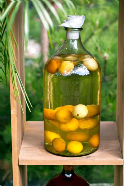 Бутылки настойки с лимоном, смородиной, ягодами и рованикой. Травяная медицина . — стоковое фото