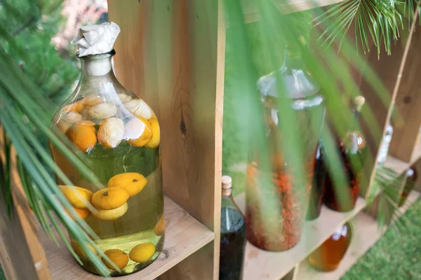 Tincture bottles of lemon, currant, berries and rowanberries. Herbal medicine. — Stock Photo, Image