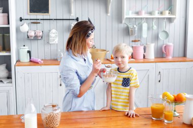 Anne ve oğul mutfakta bir kahvaltı yaparken gülüyorsun