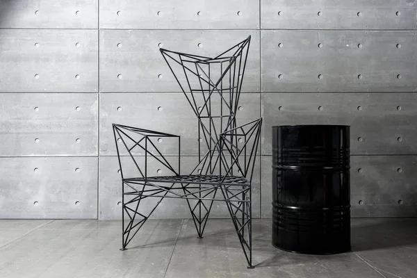 Μοντέρνα μεταλλική καρέκλα και τσιμεντένιο τοιχίο. μαύρο βαρέλι. χώρο αντίγραφο — Φωτογραφία Αρχείου