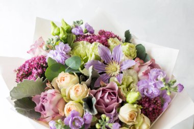 Gül ve karışık çiçek hafif bir arka plan üzerinde yakın çekim çiçek kompozisyon.