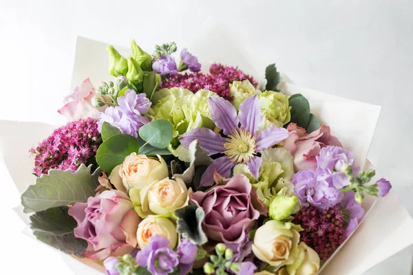 Gül ve karışık çiçek hafif bir arka plan üzerinde yakın çekim çiçek kompozisyon.