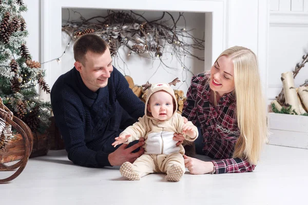 Noel mutlu bir aile. Anne ve bebeğin yerde yatarken ve gülümseyen. — Stok fotoğraf