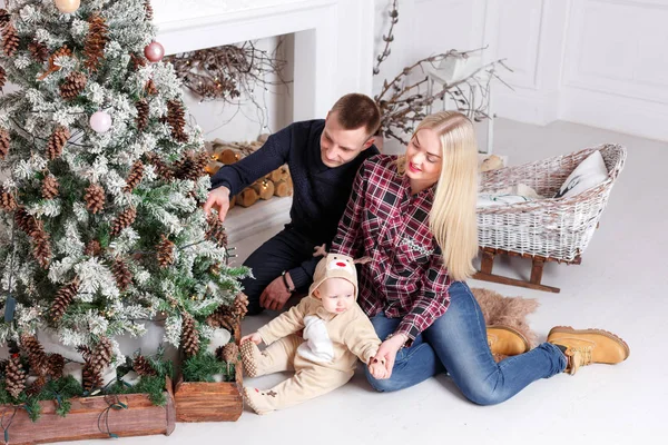 Noel mutlu bir aile. Anne ve bebeğin katta oturan ve gülümseyen. — Stok fotoğraf