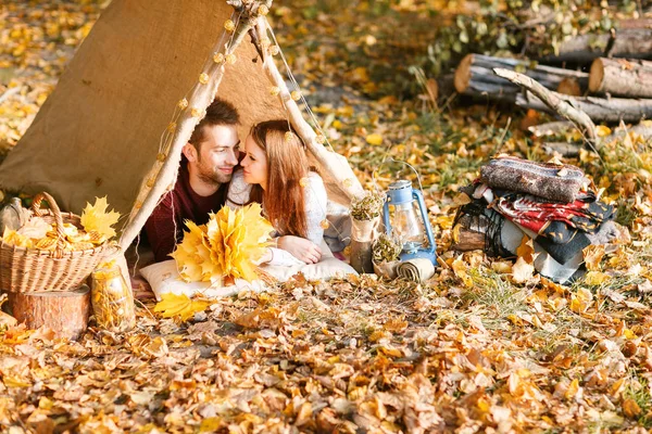Erkek ve kadın yürüyüşçü sonbahar doğada kamp. Mutlu genç çift backpackers çadırda kamp.