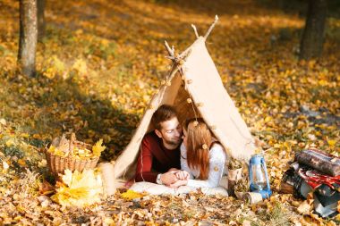 Erkek ve kadın yürüyüşçü sonbahar doğada kamp. Mutlu genç çift backpackers çadırda kamp.