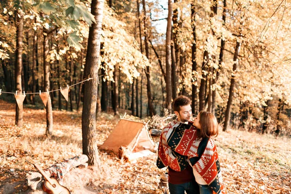 Campeggio d'autunno. felice coppia abbracci e due sotto una coperta calda — Foto Stock