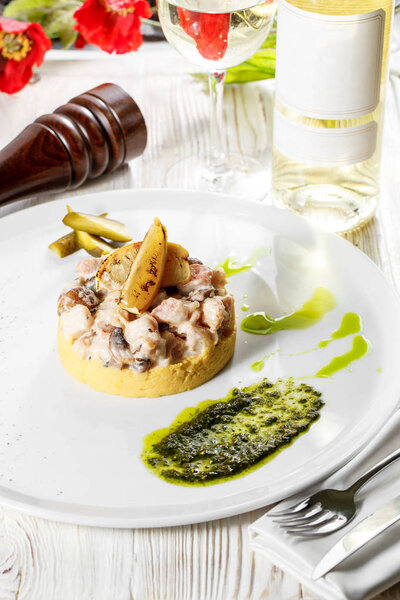 pieces of Rabbit braised in sour cream sauce with mushrooms served with mashed potatoes. on white plate.