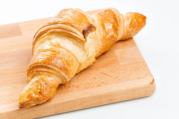 Croissant på träplatta. vit bakgrund. Ovanifrån. — Stockfoto
