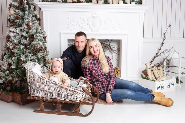 Noel mutlu bir aile. Anne ve bebeğin katta oturan ve gülümseyen.