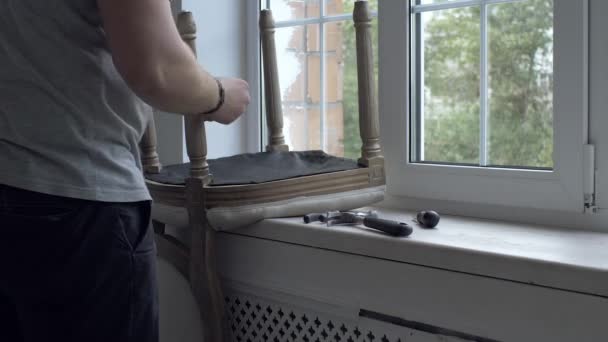 Человек ремонт кресла в комнате — стоковое видео