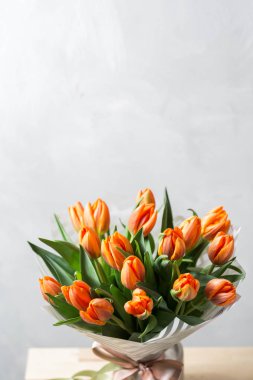 Güzel turuncu ve Sarı laleler ışık gri duvar. Çiçek arka plan. Sıcak renkler. kopya alanı