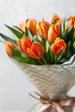 Güzel turuncu ve Sarı laleler ışık gri duvar. Çiçek arka plan. Sıcak renkler. kopya alanı