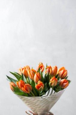 Güzel turuncu ve Sarı laleler ışık gri duvar. Çiçek arka plan. Sıcak renkler. kopya alanı