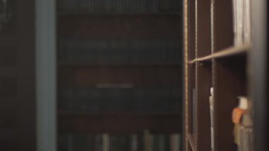 Bayan Üniversite öğrenci alarak kitap raf Kitaplığı'nda. kurşun el kitaplar raflarda