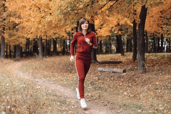 Hälsosam livsstil. atletisk flicka kör i parken och gör övningar Jogging. — Stockfoto